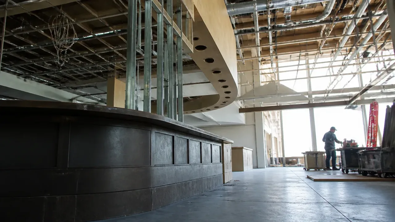 A build-out scene illustrating the politics of the signature, shot low and wide to show the height of the room